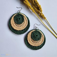 two crocheted circular earrings sitting next to each other on top of a table