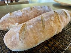 two loaves of bread sitting on top of a cooling rack