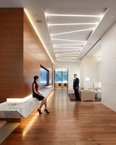 a man and woman are standing in an empty room with wood flooring on the walls