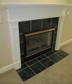 an empty fireplace in a living room with tile flooring