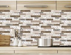 a kitchen counter with some utensils on it and a tile wall behind it