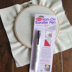 an iron - on transferer pen sitting next to a piece of fabric