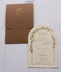 a wedding card and envelope on a marble table with a gold foil seal in the middle