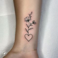 a small tattoo on the ankle of a woman's foot with flowers and heart