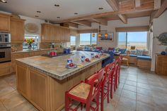 a large kitchen with lots of counter space and chairs around the island in front of it