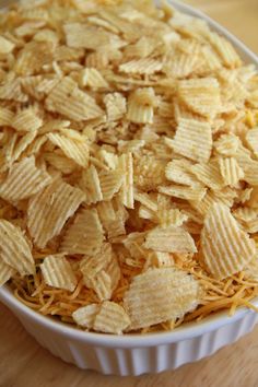 a bowl filled with cheetos sitting on top of a wooden table