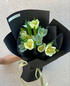 a bouquet of flowers is wrapped in black paper