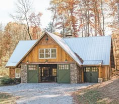 a large wooden building with two garages in the woods