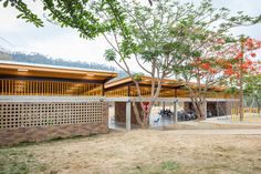 the building is made out of bricks and has trees in front of it on both sides