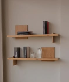 two wooden shelves with books and vases on them