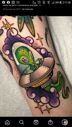 an alien in a space ship tattoo on the arm