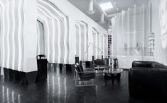 a black and white photo of a living room with chairs, couches and tables