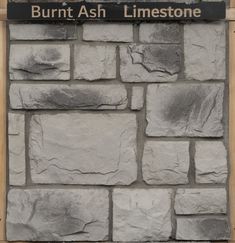 a sign on the side of a stone wall that says burnt ash limetone in black lettering