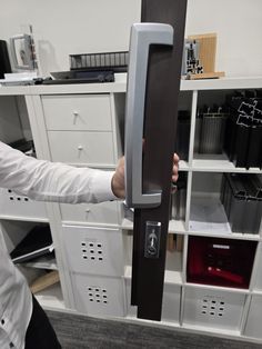 a man is opening the door to his office with many file cabinets in the background