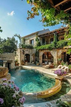 an outdoor swimming pool surrounded by greenery and stone walls, with chairs around it