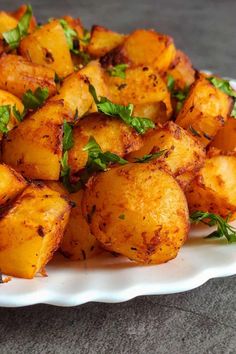 a white plate topped with potatoes covered in herbs