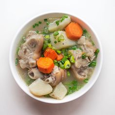 a white bowl filled with vegetables and meat