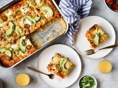 a casserole dish with zucchini, tomatoes and other vegetables on plates