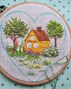 a small house in the middle of a field with trees and flowers on it's side