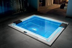 an indoor hot tub in the middle of a room with city lights on the walls