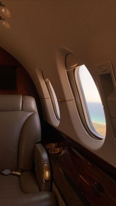 the inside of an airplane looking out at the ocean and beach through two windows with gold trim