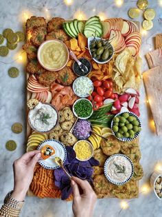 a platter filled with finger foods and dips, surrounded by condiments