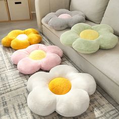 four flower shaped pillows sitting on the floor next to a couch in a living room