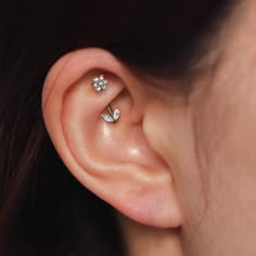 a woman's ear with two small flowers on it