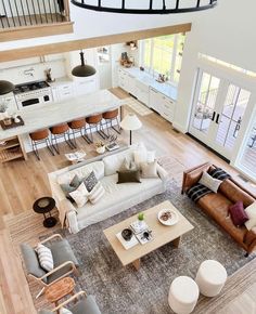 an overhead view of a living room and kitchen area with couches, chairs, coffee table