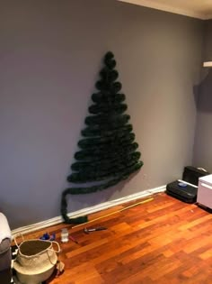 a christmas tree that is in the middle of a room with hard wood flooring