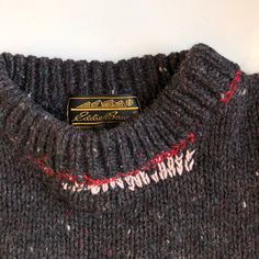 a close up of a sweater with a tag on the front and back of it