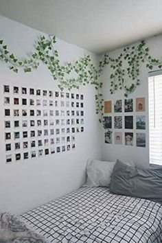 an unmade bed in a bedroom with pictures on the wall