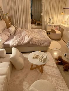 a bedroom with white furniture and lots of pillows on the bed, along with a large window