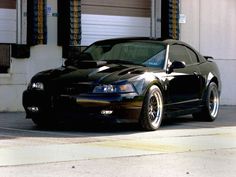 a black sports car parked in front of a garage