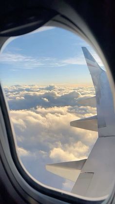 an airplane window looking out at the clouds