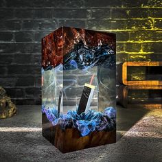 a glass box with an image of a lighter in the water and rocks on the ground