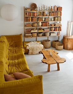 a living room filled with lots of furniture and bookshelves on top of shelves