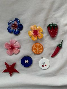 various fruits and vegetables are placed on a white sheet with red, orange, blue, and pink flowers