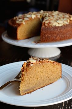 a slice of cake on a white plate with a fork in front of the pie