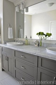 a bathroom with double sinks and two mirrors