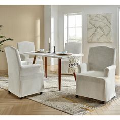 a dining room table with chairs and a rug on the floor in front of it