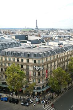 an aerial view of a city with tall buildings and people walking on the street in front of it