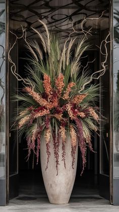 a large white vase filled with lots of different types of flowers and plants in it