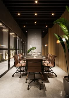 an empty conference room with several chairs and a table in the middle is lit by recessed lights