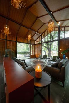 a living room with two couches and a table in front of large glass windows