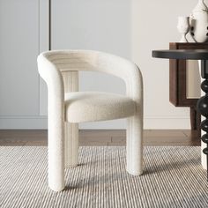 a white chair sitting on top of a rug next to a table