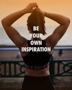 a woman standing in front of the ocean with her back to the camera and text reading be your own inspiration