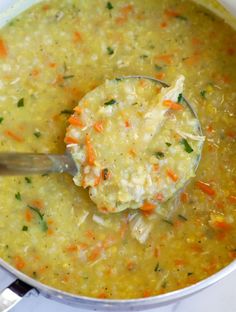 a ladle full of soup with carrots and celery