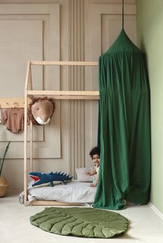 a child sitting on a bunk bed in a room with green walls and flooring