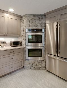 a kitchen with stainless steel appliances and granite counter tops, along with white marble flooring